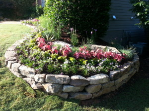 Natural stone retaining wall and flower bed